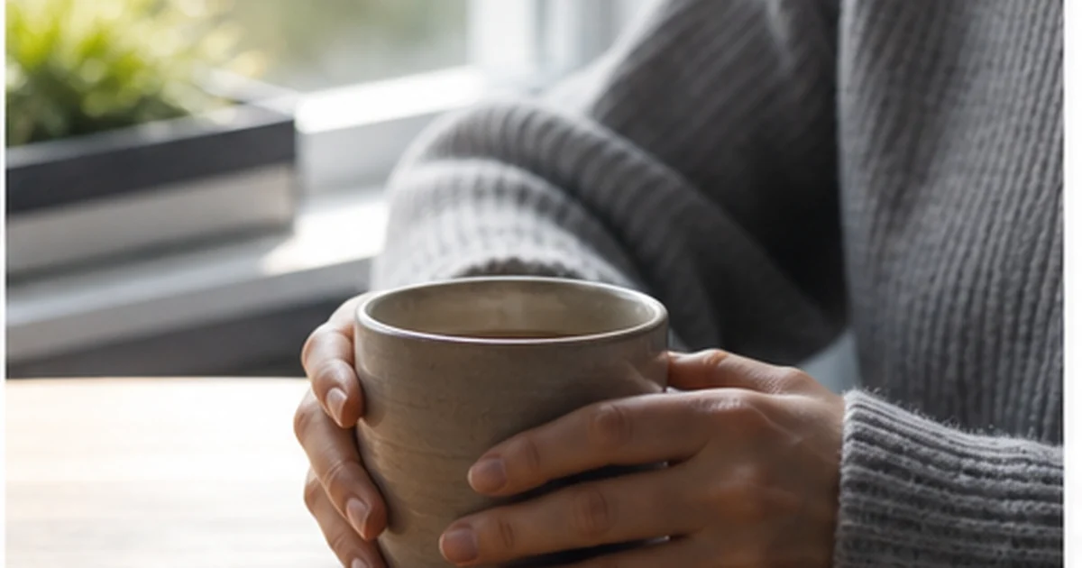 Manos junto a una taza en una pausa cotidiana de atención plena